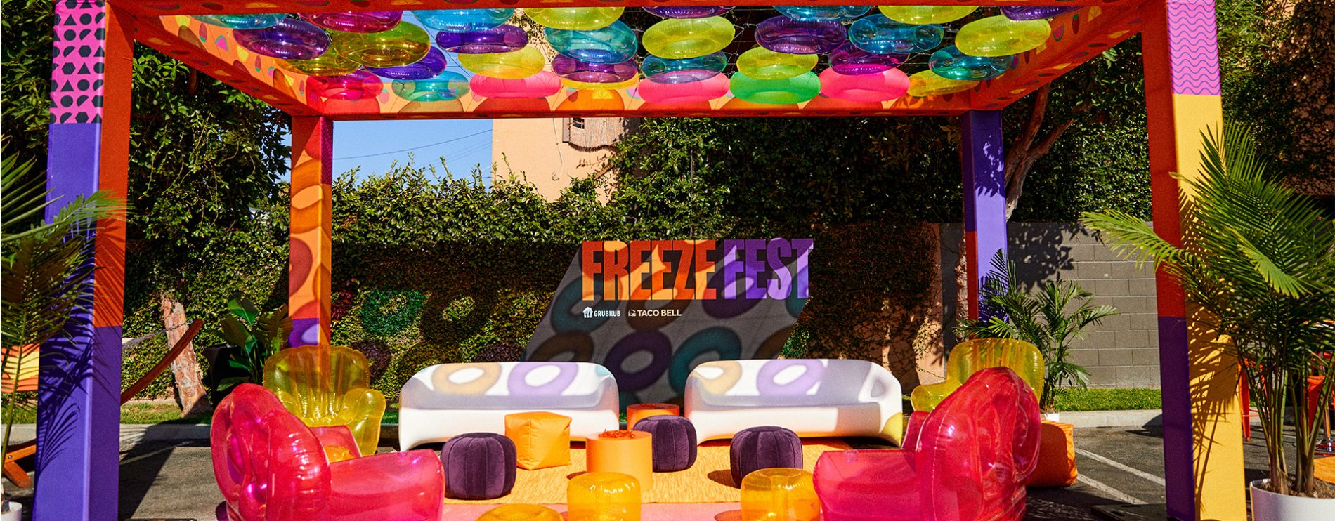 COUCHES AND BLOW UP CHAIRS SIT UNDER INNER TUBE OVERHANG AT TACO BELL X GRUBHUB FREEZE FEST